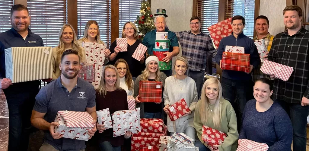 Krause Group staff show all the wrapped gifts before donating to Harbor House