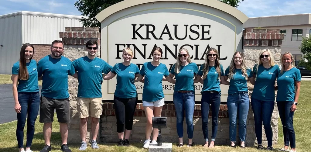Krause Group staff poses in front of their office building sign